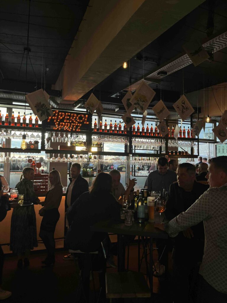 Lebendige Bar-Atmosphäre bei der After Work Party im FELIX am Augustusplatz in Leipzig – Gäste treffen sich zum Netzwerken, Feiern und Genießen bei Aperol Spritz und geselligem Ambiente.