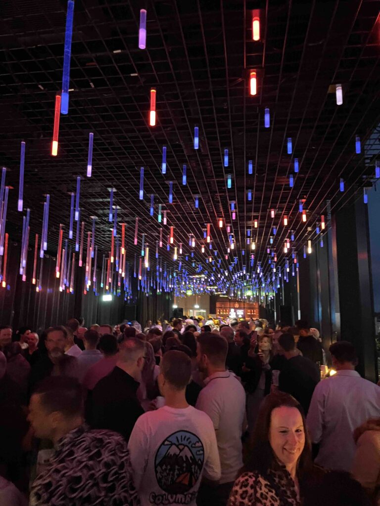Stimmungsvoll beleuchteter Innenbereich des FELIX am Augustusplatz in Leipzig bei der After Work Party – farbenfrohe Lichtinstallation, ausgelassene Stimmung und Gäste beim Feiern und Kontakte knüpfen.